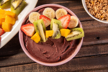 Brazilian açaí in a bowl accompanied by tropical fruits. Fruit of the Amazon