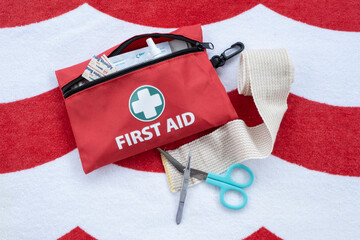 First aid medical kit and supplies on red and white background.