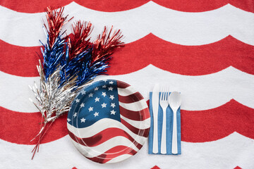 Red, white and blue paper plate picnic setting on red and white background for Fourth of July