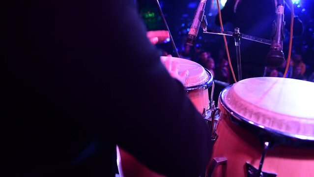 unrecognizable person playing congas, percussion musical instrument. concept band of cumbia, salsa, latin music.