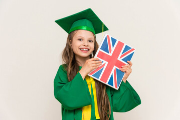 A student in a master's suit holds a book with the flag of Britain in English and smiles happily. ...