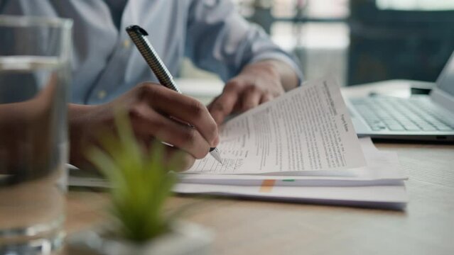Close up male hands writing exam in class business paperwork with glass of water on office desk unrecognizable man businessman student studying write paper notes document text form insurance summary