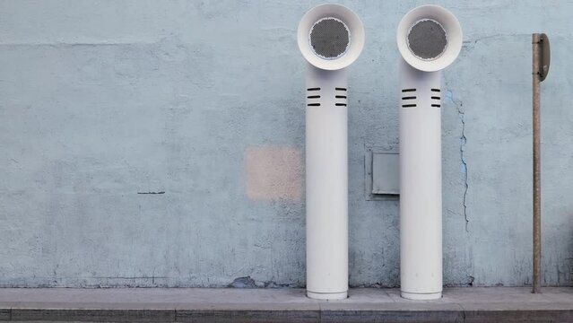 modern art in form of steamship pipes on blue background on street in asphalt on transitional path. Ventilation pipes of enterprise stick out of ground.