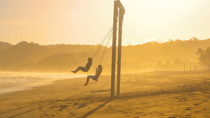 SILHOUETTE: Couple of friends on a beach swing after surf session at Playa Venao