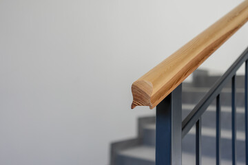 Nowoczesna stalowa barierka z drewnianym elemnetem na klatce schodowej