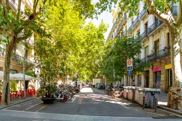 Tuinposter A tree lined street of shops in the L'Eixample district near Ciutadella Park in Barcelona, Spain. © Kirk Fisher