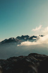 vertical photo of sunset over the mountains while climbing high altitude hills in Asturias, Spain, Clouds and fog lighted by sunrise warm light
