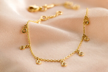 Gold  bracelet with diamond on pink background. Romantic jewelry. Advertising still life product.