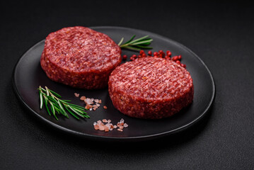 Fresh raw ground beef burger patty with salt and spices