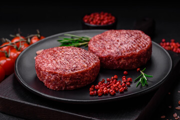 Fresh raw ground beef burger patty with salt and spices