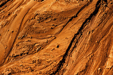 grunge, detailed close-up wet clay texture. Wet mud with drips from rain, sunlight. The surface of...