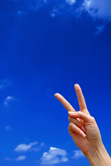 Victory sign with blue sky in the background