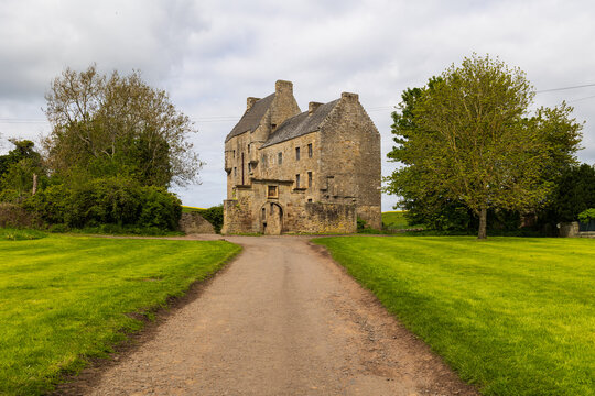 Midhope castle at the end of a path surrounded by grass (known as Lallybroch from Outlander series)