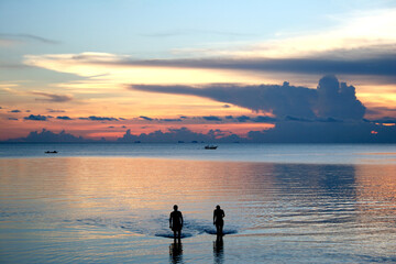 Fototapeta premium Friends taking in the sunset at a resort on Ko Pha-Ngan island in Thailand.