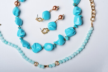 author collection jewelry with azure gemstones, pearls and chain demonstrated at white  background....