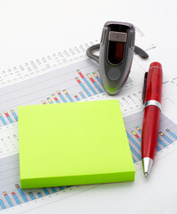 Handsfree, notes and pen on earnings chart background. Focus on handsfree.
