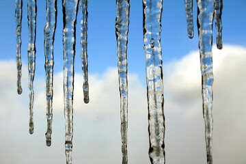 Abstract of icicles against blue sky and clouds