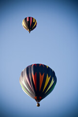 Fototapeta premium hot air balloons - two colorful balloons flying high in the clear blue sky, added vignetting