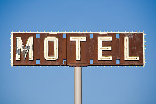 motel sign - old sign in disrepair against blue sky