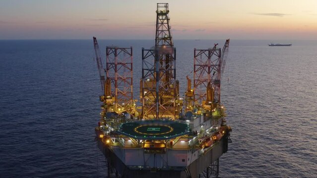 Aerial view of offshore jack up drilling rig during early night time - oil and gas industry
