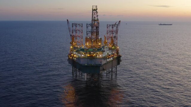 Aerial view of offshore jack up drilling rig during early night time - oil and gas industry
