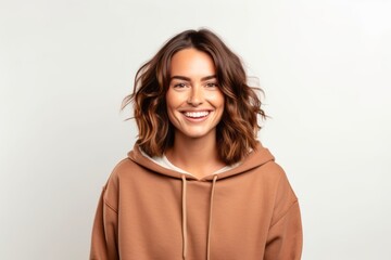 Obraz premium Portrait of a smiling young woman in a hoodie on a white background