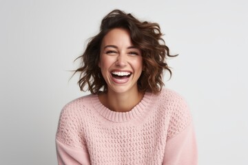 Portrait of a happy young woman laughing and looking at camera isolated over white background