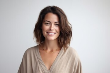 Fototapeta premium Medium shot portrait photography of a satisfied woman in her 30s that is wearing a simple tunic against a white background . Generative AI