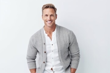 Fototapeta premium Portrait of handsome mature man in casual clothes smiling at camera while standing against white background