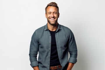 Fototapeta premium Portrait of smiling handsome man in casual clothes standing against white background