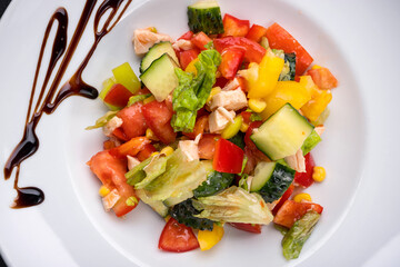 fresh vegetable and chicken fillet salad on a white plate