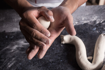 Primer plano a las manos del panadero mientras prepara la masa para hornear pan.