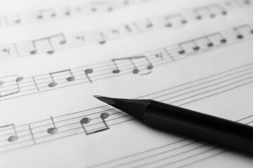 Fototapeta premium Sheet with musical notes and pencil, closeup view