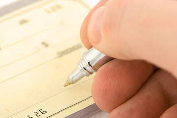 signing check close up with shallow depth of field