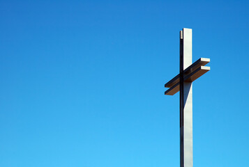 detail photo of a steel cross, blue sky