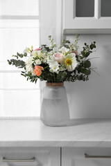 Bouquet of beautiful flowers on white countertop indoors