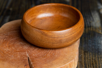 Wooden bowl on wooden table, empty round bowl for groceries and food