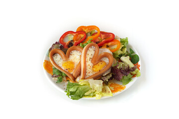 heart sausages with fried eggs on leafs salad for lovely breakfast  for Valentine's day or weekend
