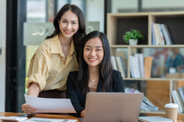 Two Asian business women Discussing new startup projects Financial reports, project presentations, analytical concepts, planning and financial statistics and investment markets at the office.