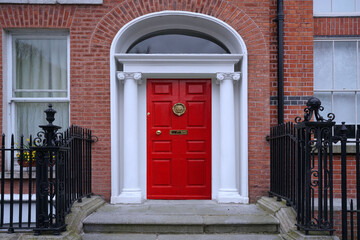 Fototapeta na wymiar Entrance to old brick townhouse with bright red door