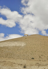 A Excavator constructing road in dry mountain in the way of Padum, Zanskar, Ladakh, INDIA. 