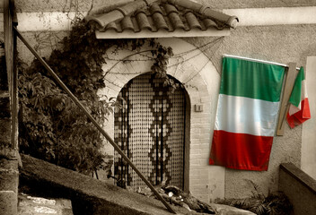 an italian flag hanging on the wall of  an old house in Picerno, IT