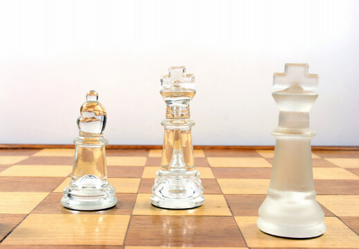 Chess Game - Glass Chess Pieces on a wooden chessboard