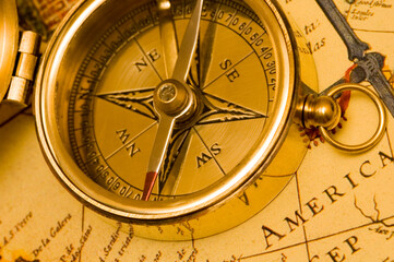 Fototapeta na wymiar Old style brass compass on antique map