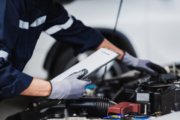 Professional mechanic working on the engine of the car in the garage. Car repair service.