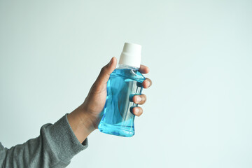  hand hold a mouthwash liquid container  - obrazy, fototapety, plakaty