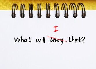 Notebook with handwritten text WHAT WILL THEY THINK? replaced THEY with I, concept of overcoming...