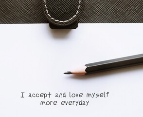 Pencil wrote on note paper positive message, I  love and accept myself more everyday - concept of...