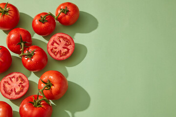 Against a pastel background, tomato and tomato cut in half are decorated. Empty area in the right side for beauty product promotion of Tomato (Solanum lycopersicum) extract