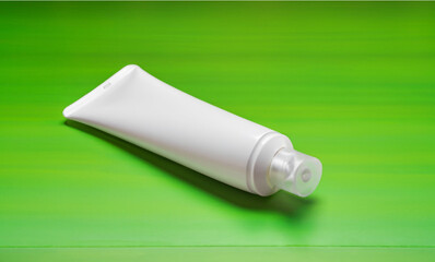 container with cream, Blank empty white plastic tube. Sunscreen lotion on table,green Screen as background